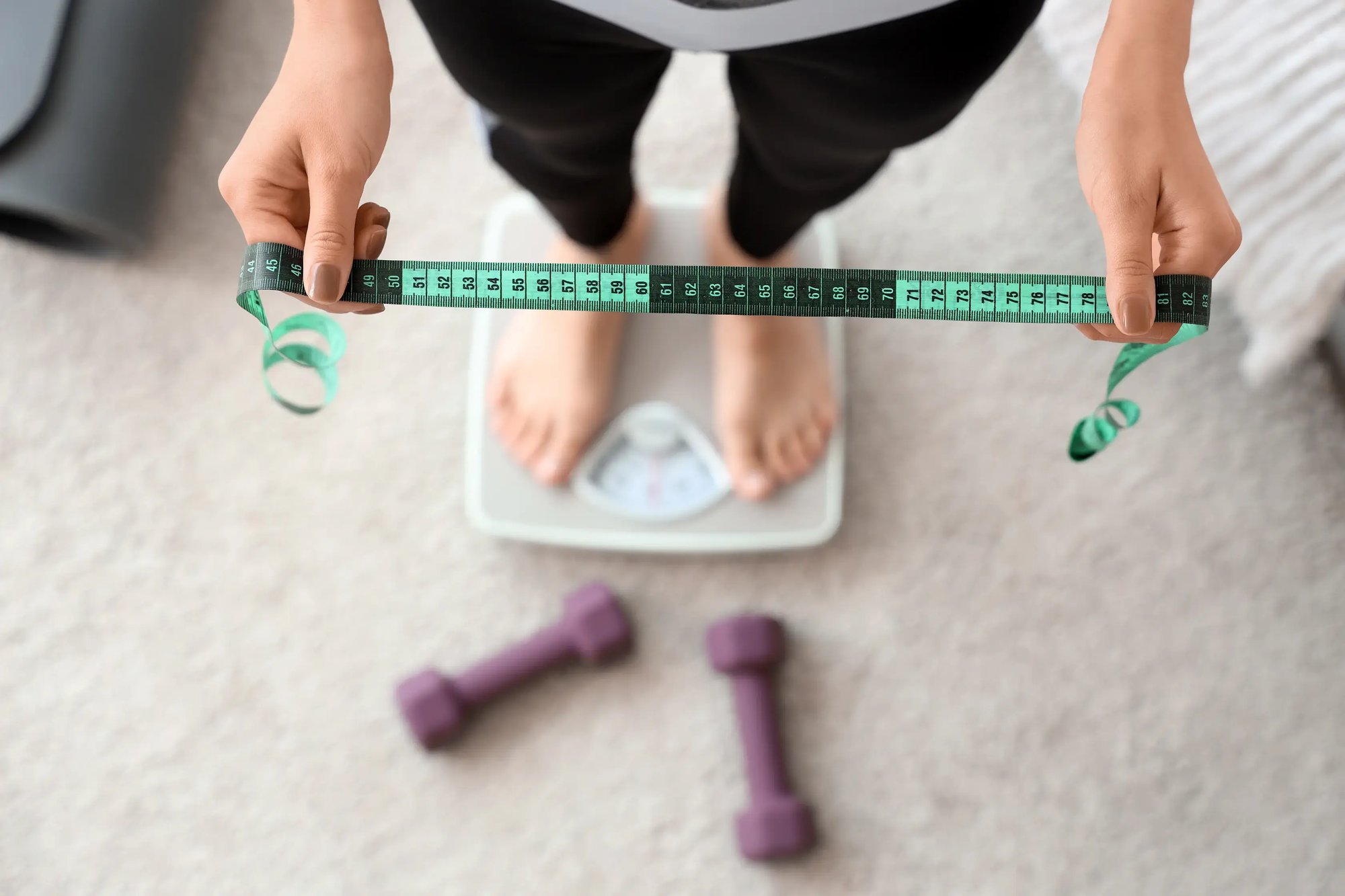 medical-weight-loss_sporty-woman-with-tape-measure-weight-scale